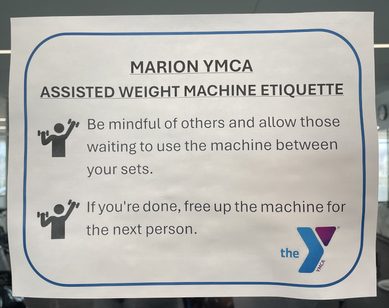 Sign reading "Marion YMCA Assisted Weight Machine Etiquette. Be mindful of others and allow those waiting to use the machine between your sets. If you're done, free up the machine for the next person."